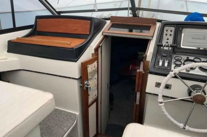 Slide: The Image of 1985 Carver 28 Riviera boat interior with helm, steering wheel, and navigation equipment. - 6