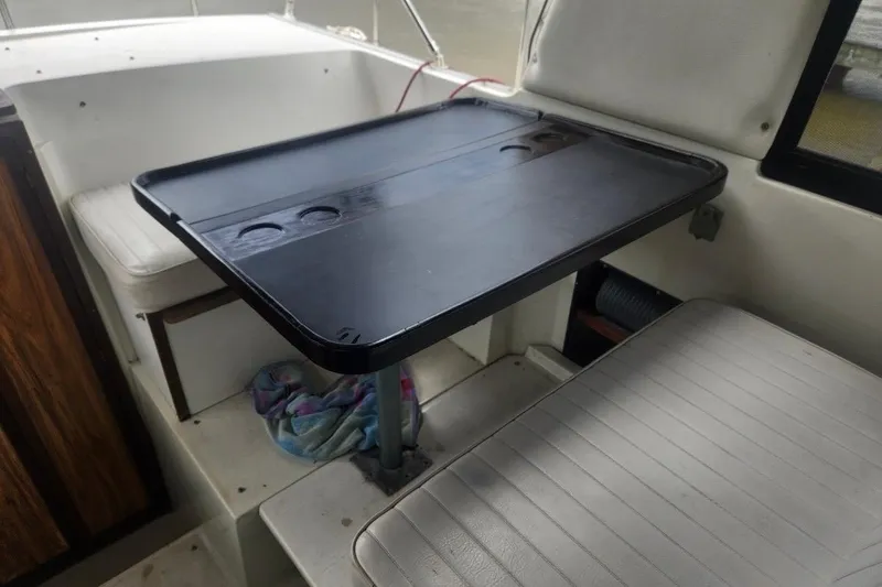 Slide: The Image of Interior of 1985 Carver 28 Riviera boat with seating and table setup. - 8