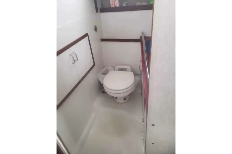 Slide: The Image of Compact bathroom in 1985 Carver 28 Riviera boat, featuring a toilet and storage cabinets. - 15