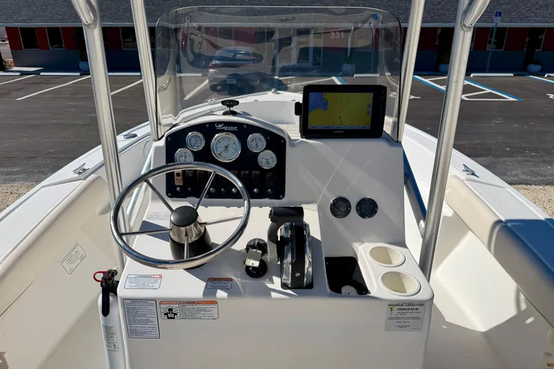 Slide: The Image of 2014 Mako 184 Center Console boat dashboard with steering wheel and navigation system. - 14