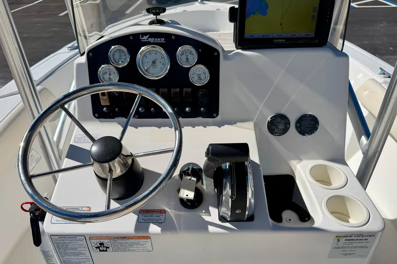Slide: The Image of 2014 Mako 184 Center Console boat dashboard with steering wheel and navigation system. - 15