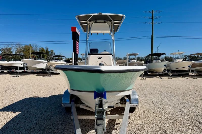 Slide: The Image of 2014 Mako 184 Center Console boat on trailer in sunny outdoor showroom. - 2