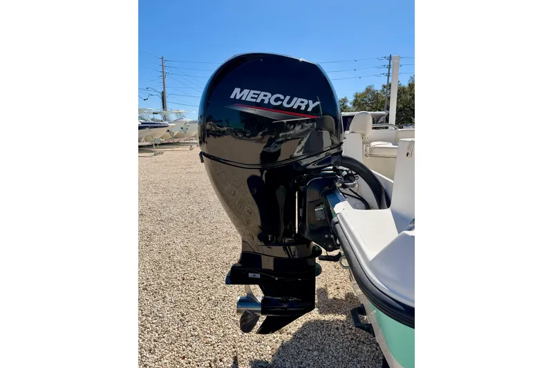 Slide: The Image of 2014 Mako 184 Center Console with Mercury outboard motor in a sunny boatyard. - 22