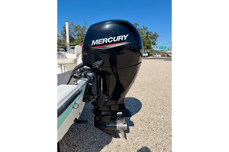 Slide: The Image of 2014 Mako 184 Center Console with Mercury outboard engine, parked on gravel. - 24