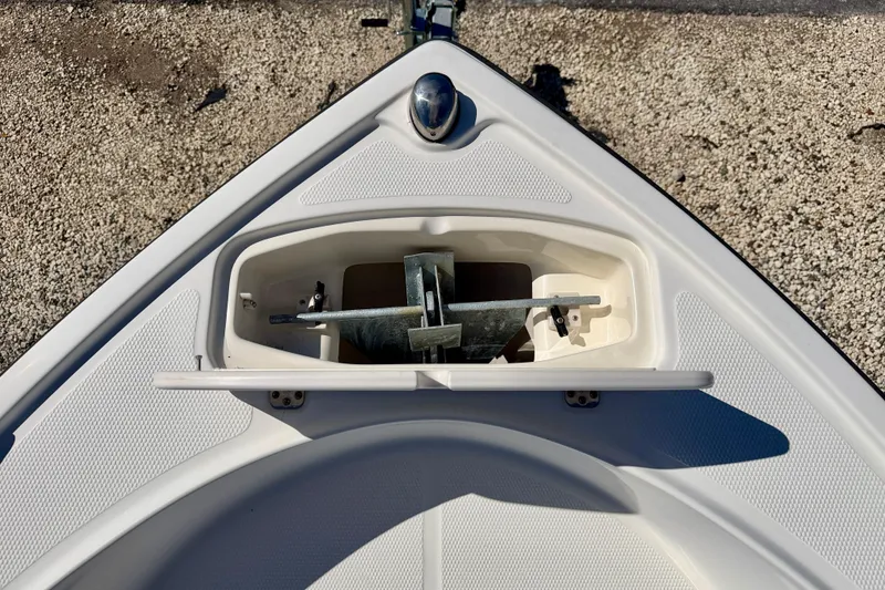 Slide: The Image of 2014 Mako 184 Center Console boat anchor compartment, open on textured deck. - 26
