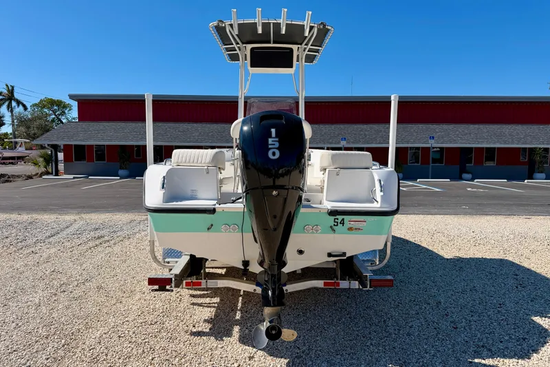 Slide: The Image of 2014 Mako 184 Center Console boat with 150 HP engine, parked on gravel. - 6
