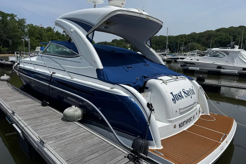 Slide: The Image of 2011 Formula 34 Performance Cruiser docked at marina, featuring sleek design and blue cover. - 2
