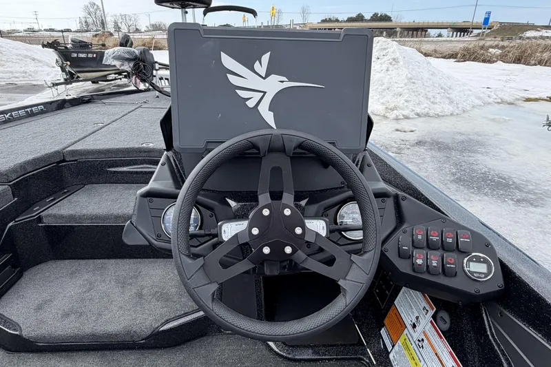 Slide: The Image of 2026 Skeeter ZXE20 boat dashboard with steering wheel and control panel in snowy setting. - 13