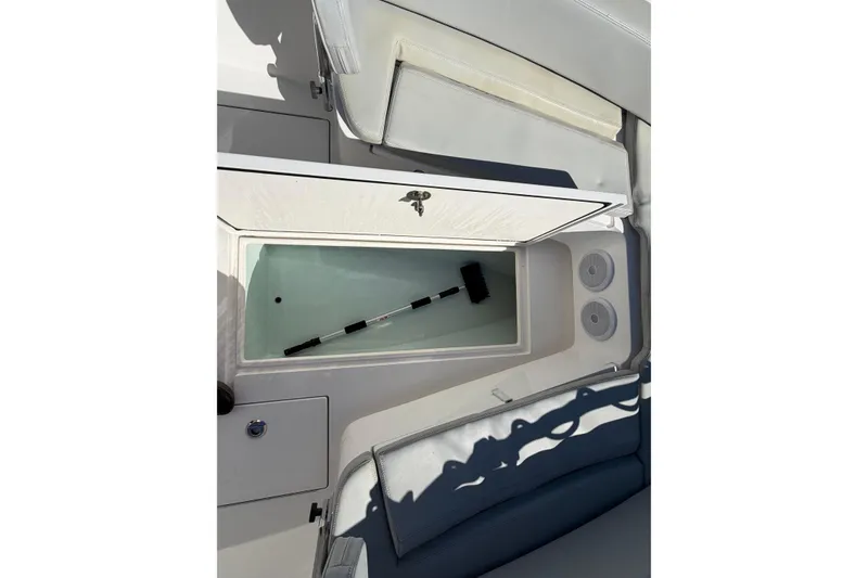 Slide: The Image of 2019 Contender 28 Tournament boat storage compartment with open lid and cleaning brush inside. - 15