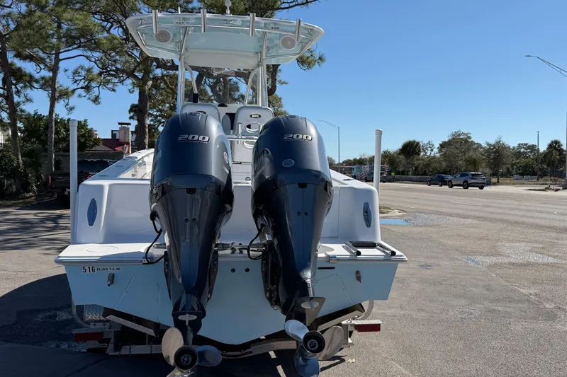 Slide: The Image of 2019 Contender 28 Tournament boat with dual 200 horsepower engines, parked outdoors. - 2