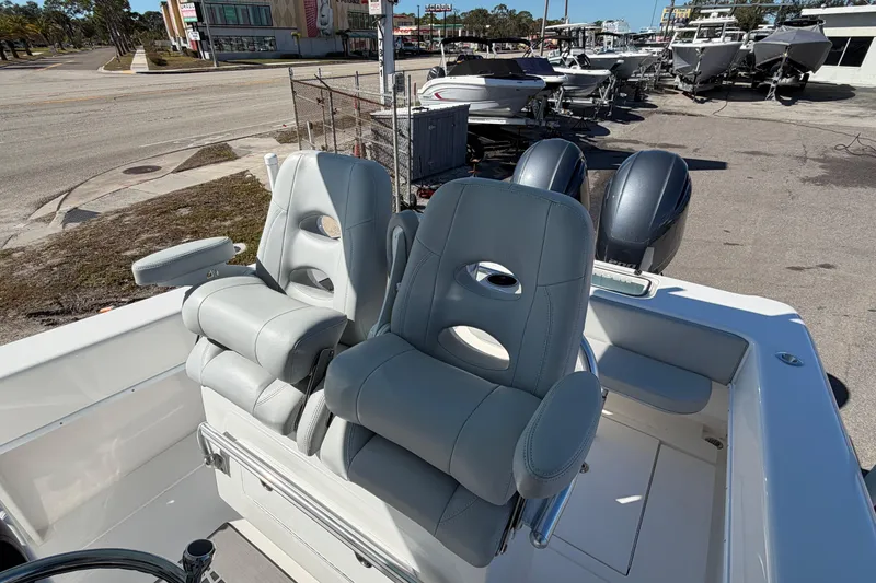 Slide: The Image of 2019 Contender 28 Tournament boat with dual seats and outboard motors at a marina. - 6