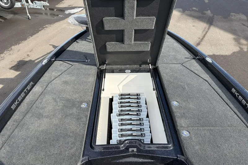 Slide: The Image of 2026 Skeeter ZXE21 boat storage compartment with organized tackle boxes. - 14