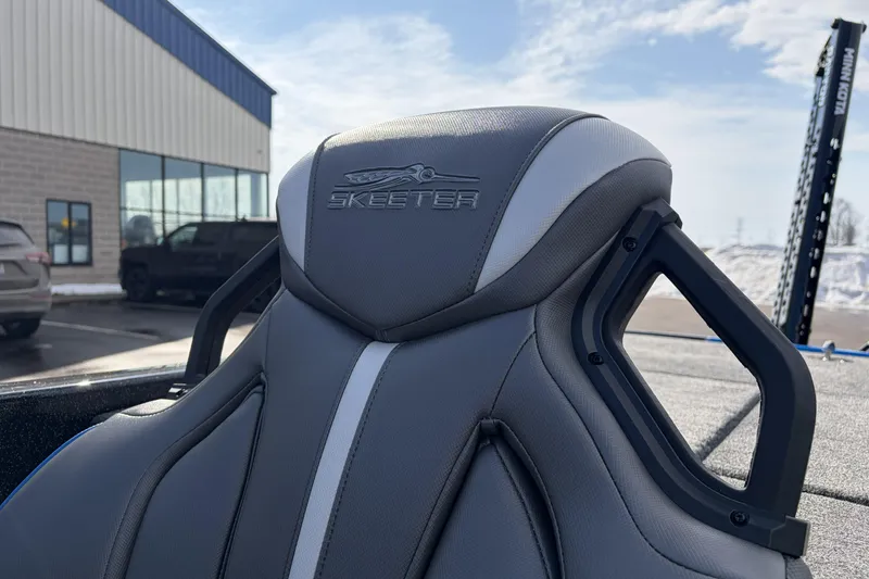 Slide: The Image of 2026 Skeeter ZXE21 boat seat with logo, parked outside a building. - 20