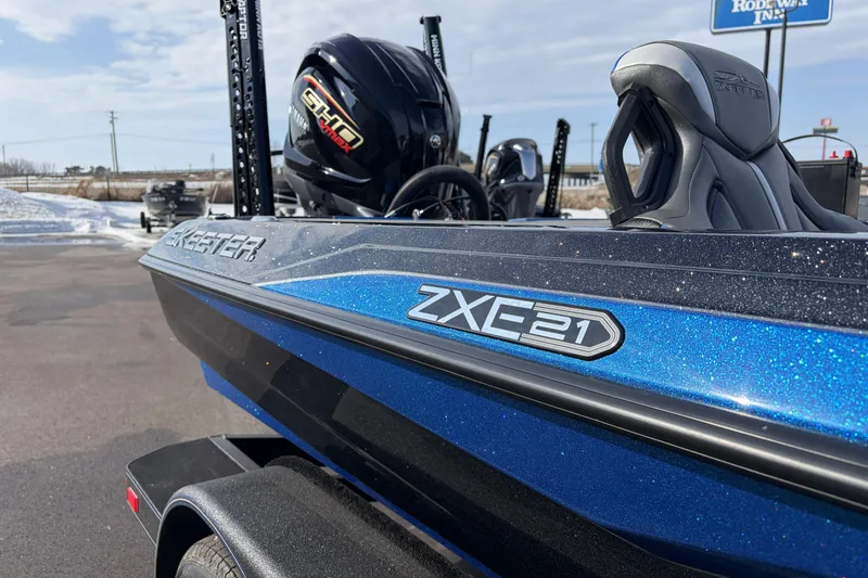 Slide: The Image of 2026 Skeeter ZXE21 boat with Yamaha engine, blue and black design, parked outdoors. - 22