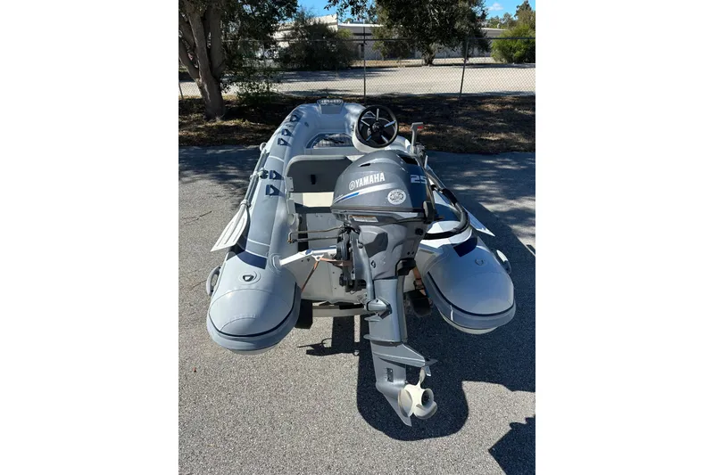 Slide: The Image of 2023 Highfield Classic 340 FCT inflatable boat with Yamaha outboard motor, parked outdoors. - 2