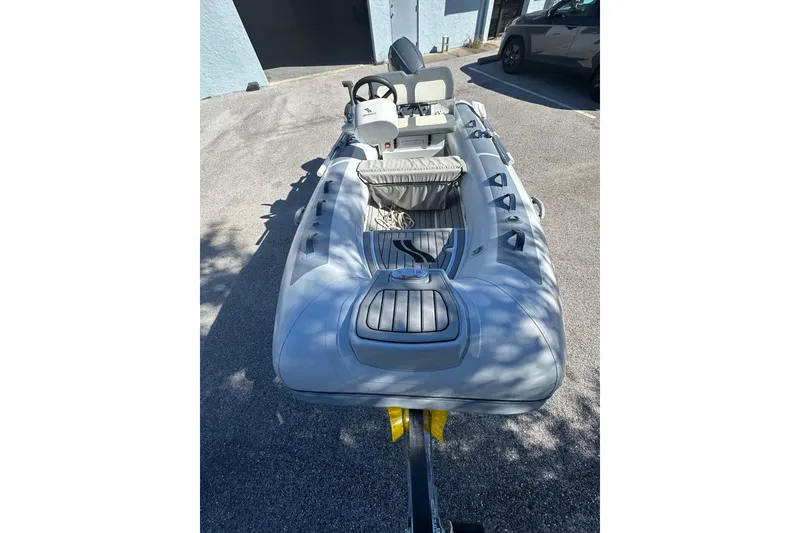 Slide: The Image of 2023 Highfield Classic 340 FCT inflatable boat, parked outdoors, showcasing interior seating and controls. - 3