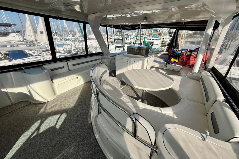 Slide: The Image of Spacious interior of a 1999 Bluewater 5800 yacht with seating and marina view. - 13
