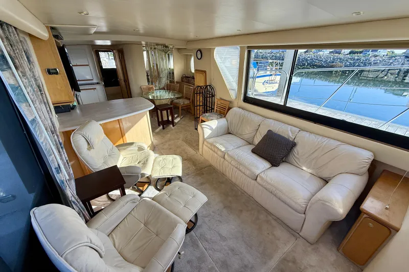 Slide: The Image of Luxurious interior of 1999 Bluewater 5800 yacht with comfortable seating and large windows. - 23