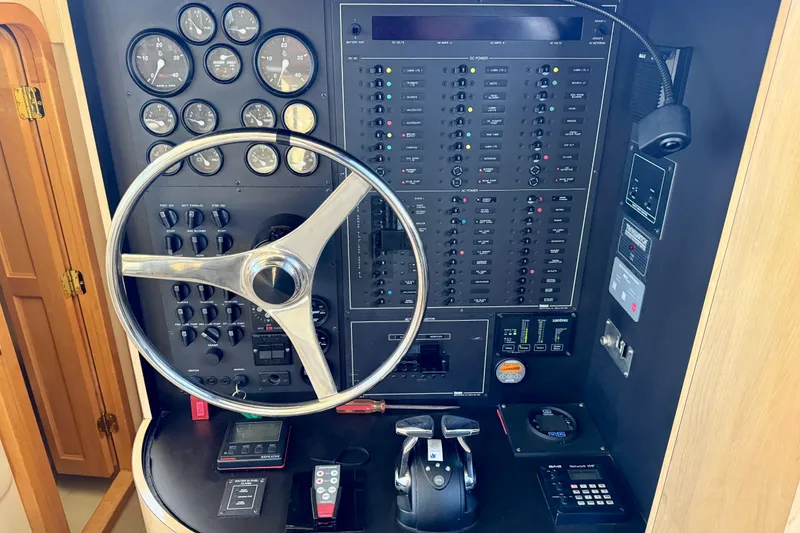 Slide: The Image of Control panel of a 1999 Bluewater 5800 yacht with steering wheel and gauges. - 25