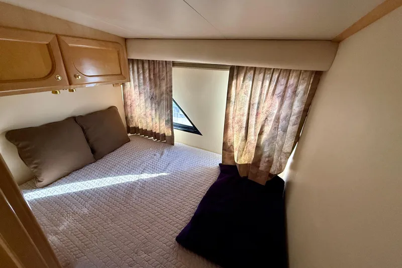 Slide: The Image of Cozy bedroom in 1999 Bluewater 5800 yacht with bed, pillows, and curtains. - 27
