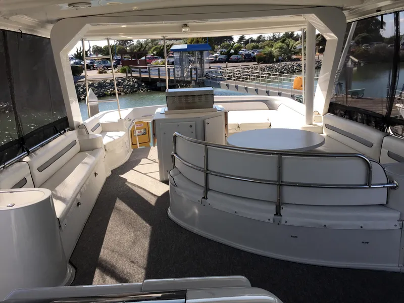 Slide: The Image of Interior of a 1999 Bluewater 5800 yacht, featuring seating area and table. - 37