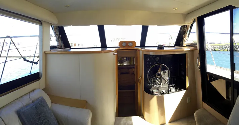 Slide: The Image of Interior of a 1999 Bluewater 5800 yacht, featuring helm and seating area. - 41