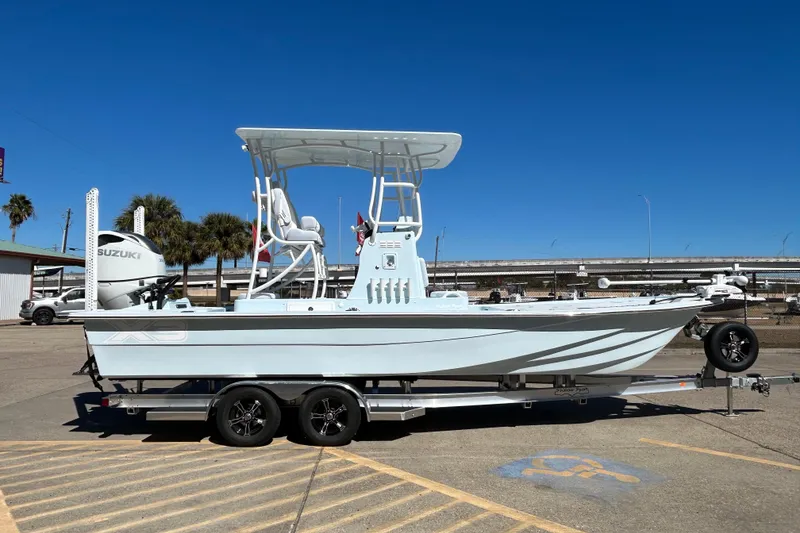 Slide: The Image of 2026 Shallow Sport 25 X3 boat on trailer, featuring Suzuki engine, clear blue sky. - 3