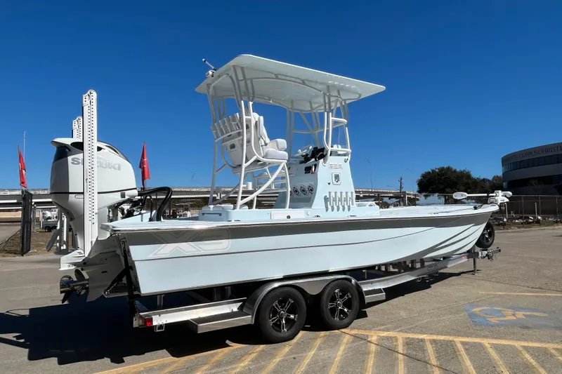 Slide: The Image of 2026 Shallow Sport 25 X3 boat on trailer, featuring Suzuki engine, under clear blue sky. - 4