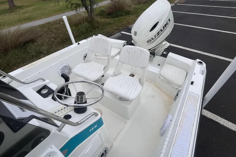 Slide: The Image of 1995 Wahoo 2100 EFS boat interior with Suzuki outboard motor, featuring white seating and steering wheel. - 10