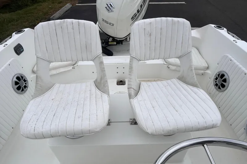 Slide: The Image of 1995 Wahoo 2100 EFS boat interior with white seats and Suzuki engine. - 13