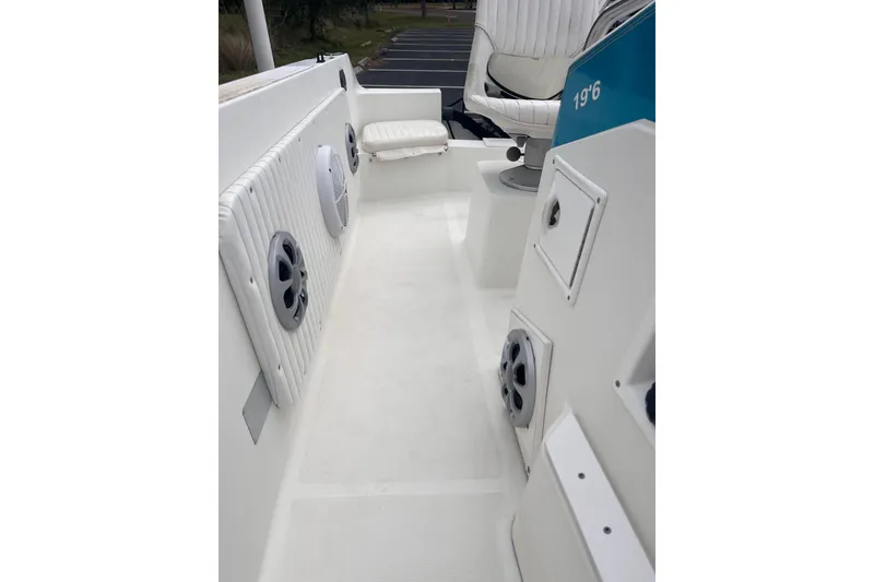 Slide: The Image of 1995 Wahoo 2100 EFS boat interior with white seating and speaker system. - 14