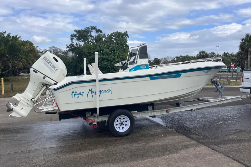 Slide: The Image of 1995 Wahoo 2100 EFS boat on trailer with Suzuki outboard motor, parked outdoors. - 20