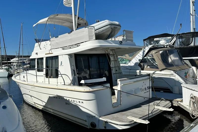 The Image of 2016 Beneteau Swift Trawler 34 docked at marina, rear view. - 0