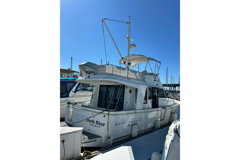 Slide: The Image of 2016 Beneteau Swift Trawler 34 docked, showcasing flybridge and sleek design. - 2