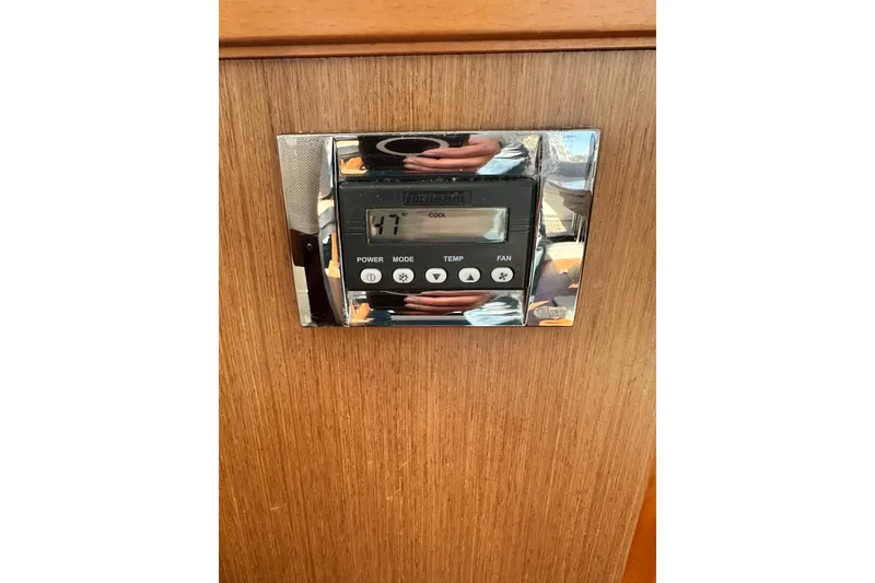 Slide: The Image of Thermostat control panel on 2016 Beneteau Swift Trawler 34, mounted on wooden surface. - 51