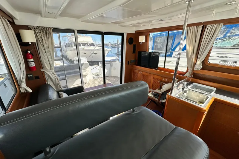 Slide: The Image of Interior of 2016 Beneteau Swift Trawler 34, featuring seating, sink, and marina view. - 55