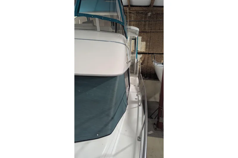 Slide: The Image of 1996 Carver 355 Aft Cabin Motor Yacht in storage, side view with blue canopy. - 13