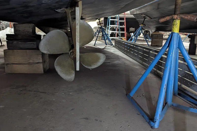 Slide: The Image of 1996 Carver 355 Aft Cabin Motor Yacht propeller and hull on stands in a workshop. - 32