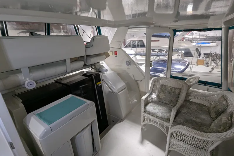 Slide: The Image of 1996 Carver 355 Aft Cabin Motor Yacht interior with wicker seating and helm station. - 4