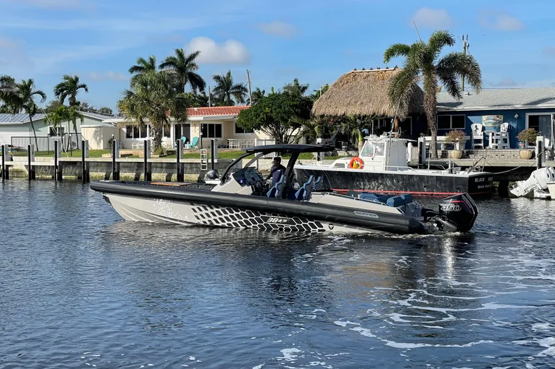 The Image of 2023 Skipper-BSK BSK 38 boat cruising near waterfront homes with palm trees. - 0