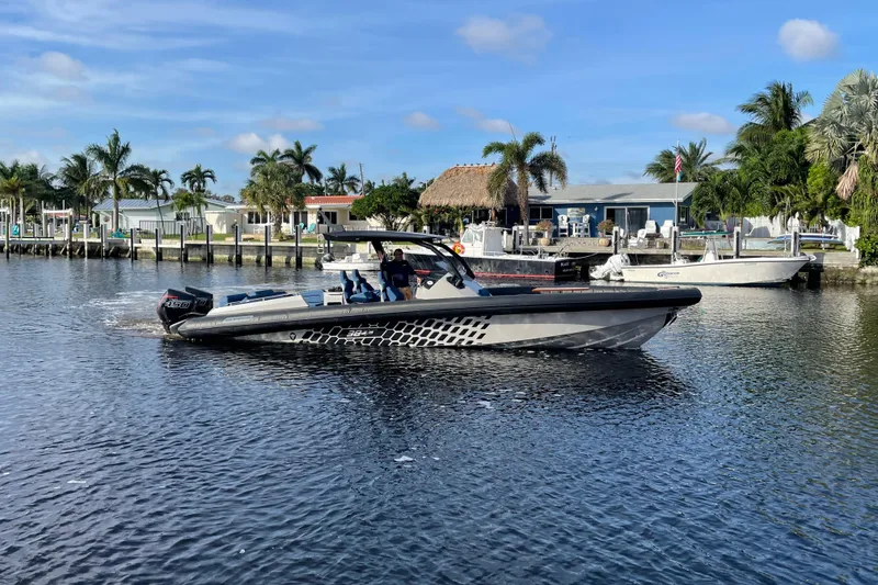Slide: The Image of 2023 Skipper-BSK BSK 38 boat cruising on a sunny waterfront with palm trees. - 12