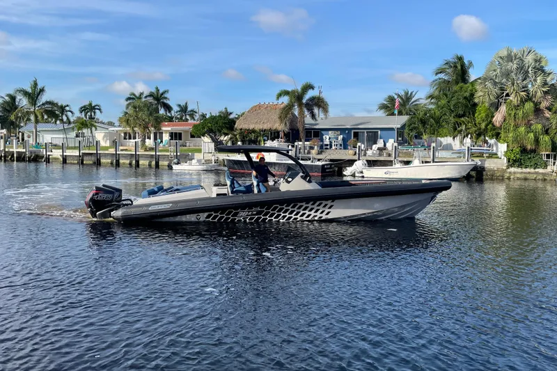Slide: The Image of 2023 Skipper-BSK BSK 38 boat cruising on a sunny waterfront with palm trees. - 13