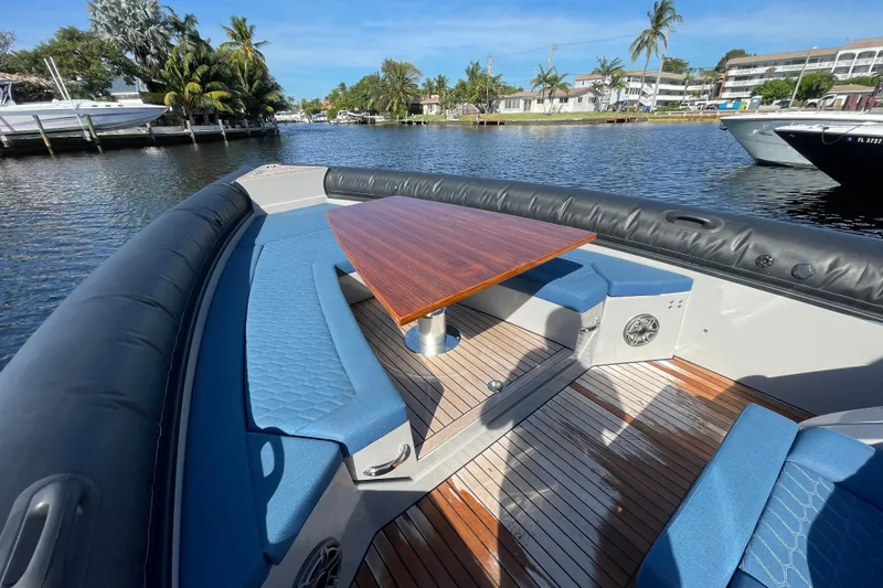 Slide: The Image of 2023 Skipper-BSK BSK 38 boat with blue seating and wooden table on a sunny day. - 19