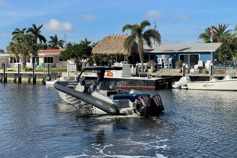 Slide: The Image of 2023 Skipper-BSK BSK 38 boat cruising near waterfront homes and palm trees. - 2
