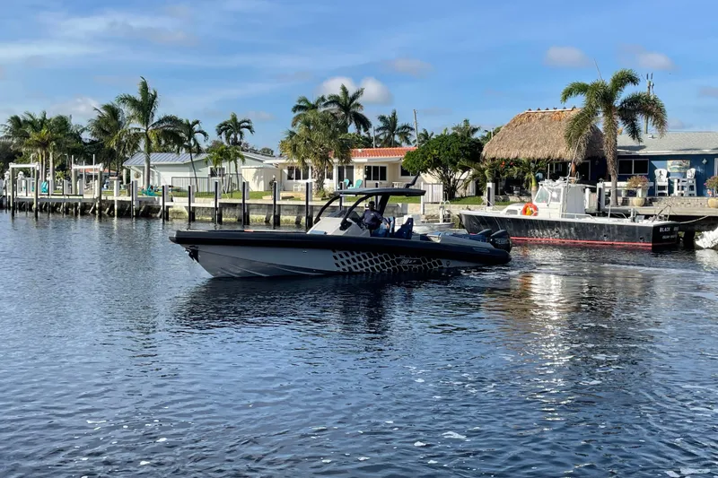 Slide: The Image of 2023 Skipper-BSK BSK 38 boat cruising on a sunny waterfront with palm trees. - 6