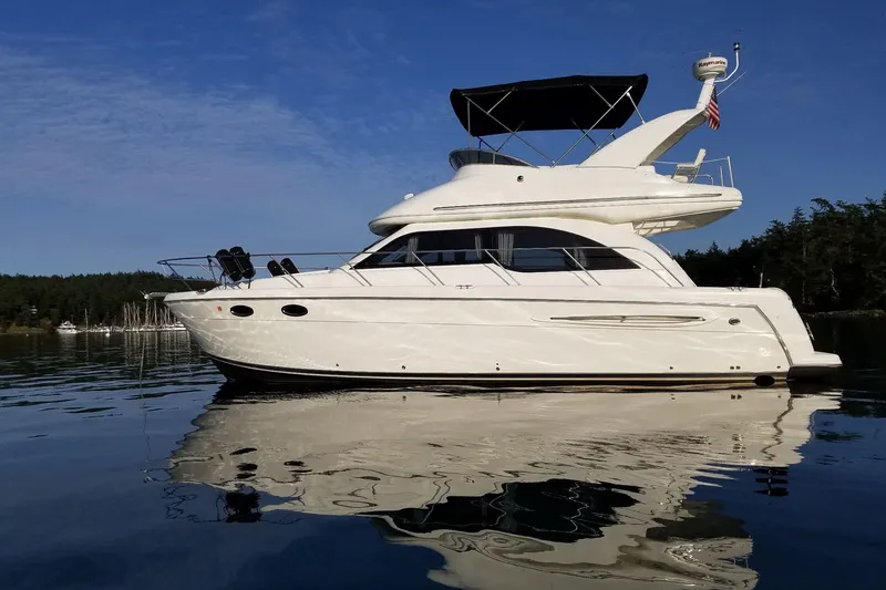 The Image of 2005 Meridian 341 Sedan yacht on calm water under clear blue sky. - 0