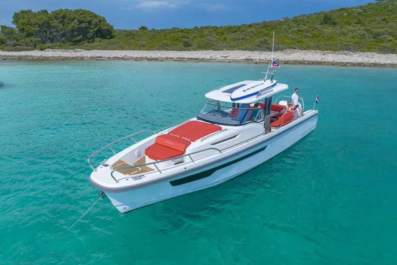 Slide: The Image of Nimbus Tender 11 boat 2025 on turquoise water near coastline. - 2