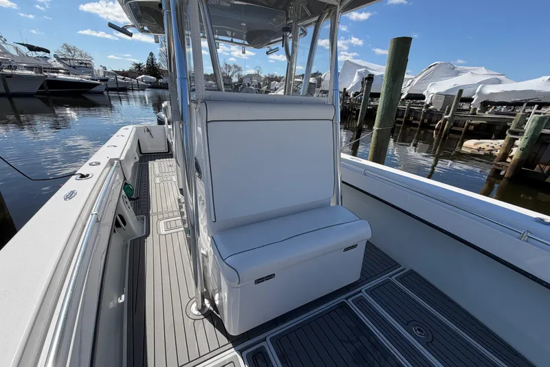 Slide: The Image of 2015 Contender 32 ST boat interior with seating, docked at marina under blue sky. - 13