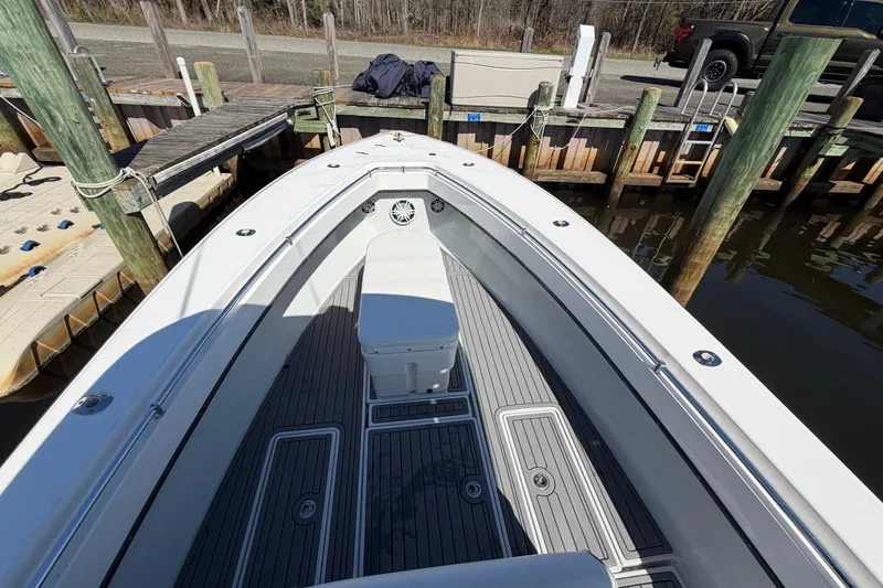 Slide: The Image of 2015 Contender 32 ST boat docked, showcasing spacious deck and seating area. - 15