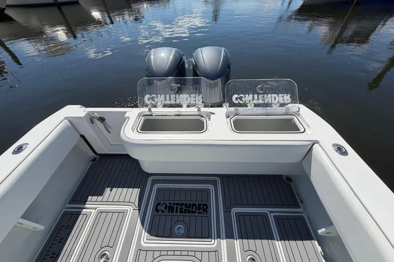 Slide: The Image of 2015 Contender 32 ST boat with dual engines and open deck, docked on calm water. - 16